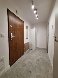 Cashmere Stay Suwalki في سووالكي: ممر فيه باب خشبي وثلاجة