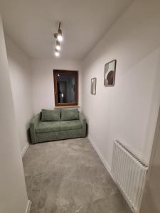 Cashmere Stay Suwalki في سووالكي: غرفة معيشة مع أريكة خضراء في الزاوية