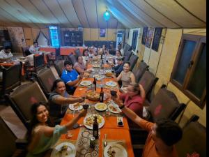 un grupo de personas sentadas en una mesa larga en Hayati Desert Luxury Camp, en Merzouga 54 fotos más
