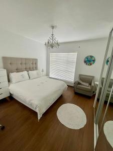 ein Schlafzimmer mit einem großen Bett und einem Stuhl in der Unterkunft Luxury Beach Front Apartment in Strand