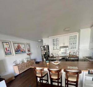 eine Küche mit einem Holztisch und Stühlen sowie eine Küche mit einer Theke in der Unterkunft Luxury Beach Front Apartment in Strand + 20 Fotos