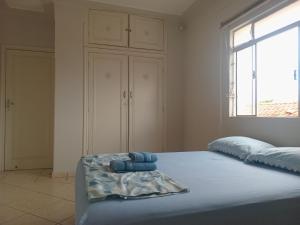 una camera da letto con un letto con asciugamani sopra di Capsula Residence Hotel a Marília