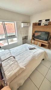 una camera da letto con un letto e una TV di Refúgio à Beira-Mar Cabo Branco João Pessoa a João Pessoa