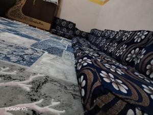 uma cama com uma colcha preta e branca no chão em البيت السيوي em Oásis de Siuá mais 3 fotografias