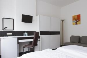 une chambre avec un lit et un bureau avec un ordinateur dans l'établissement Aparthotel VEGA, à Berlin 16 autres photos
