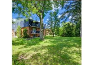 a large house with a tree in the yard at Luxurious Two Bedroom Apartment in Burlington