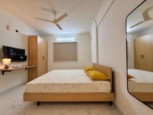une chambre avec deux lits et un miroir dans l'établissement HomeSlice Sarjapur - Balcony Rooms, à Bangalore