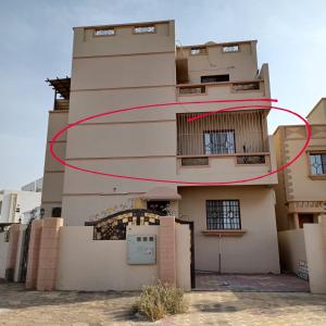 ein Gebäude mit einem roten Kreis an der Seite in der Unterkunft Raha rooms in Seeb