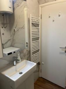 un bagno bianco con lavandino e specchio di Apartman Savanovic a Banja Luka Altre 11 foto