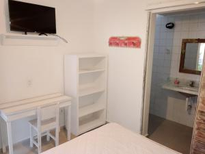 a bedroom with a desk and a sink and a mirror at Vila Luiza Ubatuba in Ubatuba
