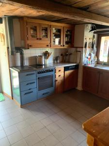 a kitchen with a blue stove and wooden cabinets at Relax alpino con sauna - Ca da Viola in Cavagnago