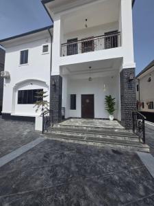 a large white house with a staircase in front of it at The White Residence, Jabi, Abuja in Abuja