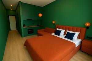 um quarto com uma cama laranja e uma parede verde em Luxury Apartments With Mountain View in Neo New Gudauri em Gudauri