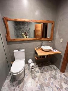 een badkamer met een toilet, een wastafel en een spiegel bij Azlins House in Tena +19 foto's