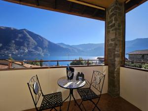 a table and chairs on a balcony with a view of the water at Dimora Paradise in Laglio