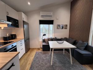 The Fäxaåsen cabin في فاربرغ: مطبخ وغرفة معيشة مع طاولة وأريكة