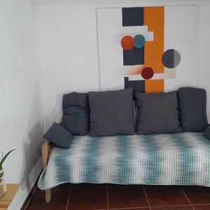 Un sofá en una sala de estar con un cuadro en la pared. en Kalma, en Villa Elisa