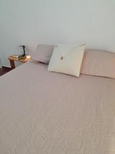 a bed with two pillows on top of it at Kalma in Villa Elisa