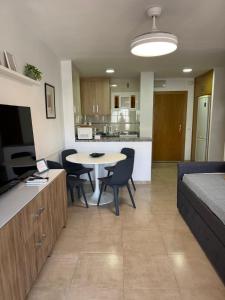 a living room with a table and chairs and a kitchen at Minerva 211 - 24h reception - 1 bedroom in Benalmádena