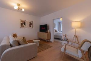 un salon avec un canapé et une télévision dans l'établissement SaLi - Design Apartments, à Trossingen