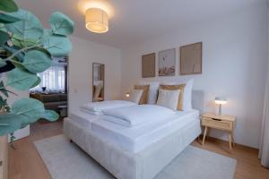 - une chambre blanche avec un lit et un canapé dans l'établissement SaLi - Design Apartments, à Trossingen