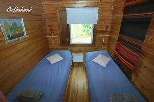 En eller flere senge i et værelse på Riverside Cabin beneath the Northern Lights