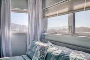 1 Schlafzimmer mit 2 Fenstern und 1 Bett mit Kissen in der Unterkunft Blue Heron - Pacific City in Pacific City