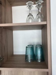 three glass vases are sitting on a shelf at Departamento frente a la playa in Iquique +7 photos