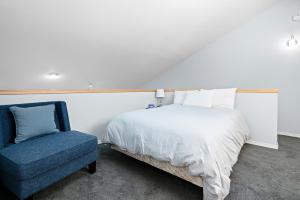 a bedroom with a bed and a blue chair at Ski House 217 in Bend +34 photos