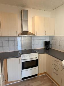 2 bedroom apartment in the heart of Randers في راندرس: مطبخ مع فرن أبيض على الموقد بجوار الخزائن