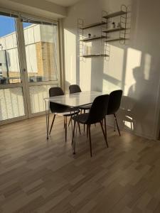 2 bedroom apartment in the heart of Randers في راندرس: طاولة طعام وكراسي في الغرفة