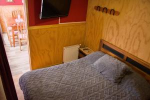a bedroom with a bed and a flat screen tv at Departamento Hikari in Puerto Natales