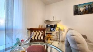 Relax & Comfort 30 min from Milan and Rho Fair في نوفارا: غرفة معيشة مع طاولة زجاجية وأريكة