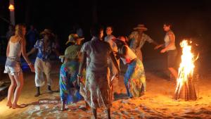 un grupo de personas bailando alrededor de un fuego en Unique Beachfront hotel, en La Digue