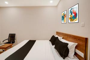 a bedroom with a white bed with black and white pillows at Hotel O The Classic Crown in Jālahalli +21 photos