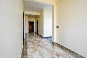 un corridoio vuoto con pavimenti in marmo e pareti bianche di SPOT ON Hotel Bella Vista a Jhinjhak