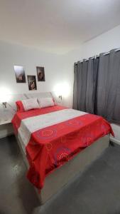 a bedroom with a large bed with a red blanket at Pousada Gaturama suite 1 in Corumbá +9 photos