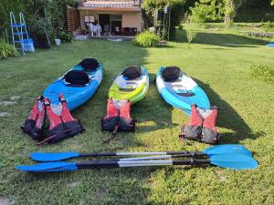 three kayaks and paddles sitting on the grass at Kuća za odmor Una in Dvor