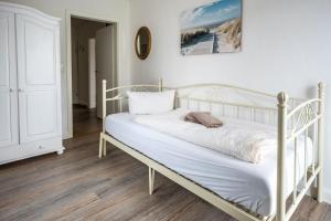 a white bed in a white room with a picture on the wall at Claras Gartenblick in Schwerin, Nähe Schloss, Hbf & Altstadt, ruhige zentrale Lage, kostenfreie Parkplätze in Schwerin