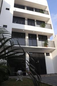 een wit gebouw met balkons en een tafel ervoor bij Habitacion con baño privado La Perla in Acapulco