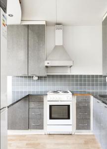 a kitchen with a white stove top oven at Tapulikaupunki Apartment Helsinki in Helsinki