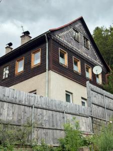 una casa con una valla delante en Sauna Chata BedRich, en Bedřichov 4 fotos más