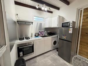 a kitchen with a stainless steel refrigerator and a dishwasher at L'Abri BEAUCI- TURLET in Goyave