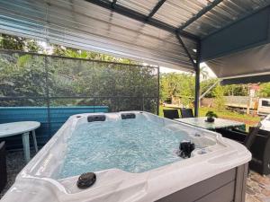 a hot tub in a backyard with a table at L'Abri BEAUCI- TURLET in Goyave