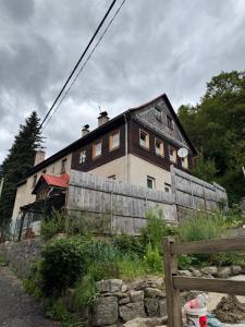 una casa con una valla de madera delante de ella en Sauna Chata BedRich, en Bedřichov