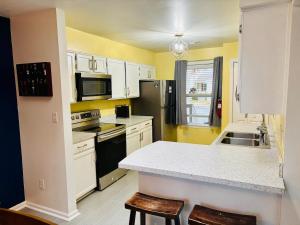 a kitchen with white cabinets and a black refrigerator at The Williamsburg Haven in Williamsburg