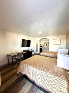 a hotel room with two beds and a desk at Kermit Inn in Kermit +2 photos