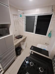 Una pequeña cocina con un horno negro. en Family Flat PG - Praia, Musica e Gastronomia, en Praia Grande