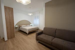 ein Wohnzimmer mit Sofa und Bett in der Unterkunft Casa di Viola - Fiori d arancio in Latina