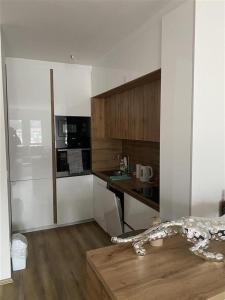 een keuken met witte muren en een houten vloer bij Luxury CH Apartments in Pristina